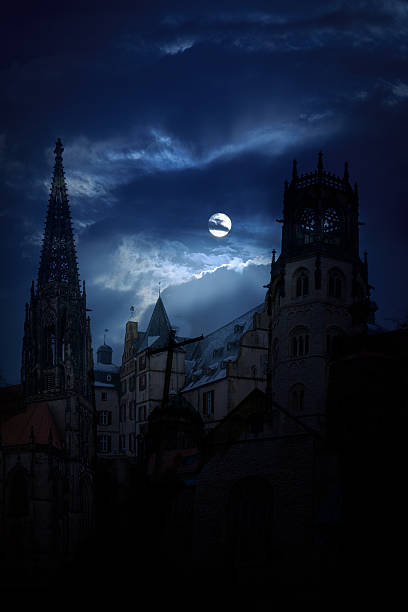 Mysterious medieval castle and the cathedral church at night on a background of the full moon