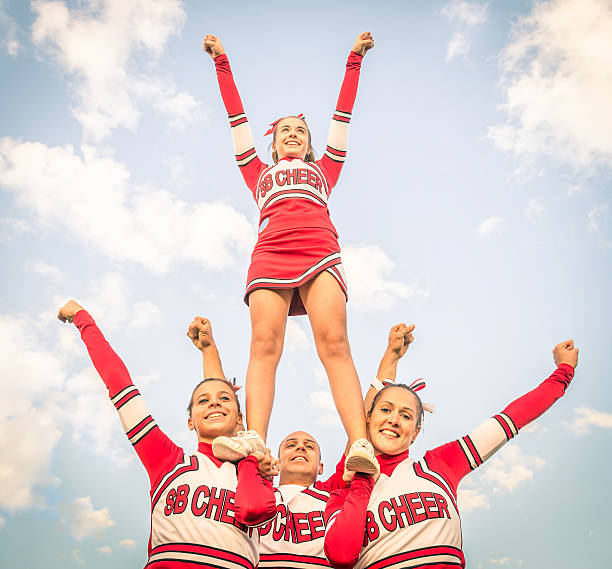 Cheerleader team with a male member posing Cheerleaders team with male Coach cheerleader photos stock pictures, royalty-free photos & images