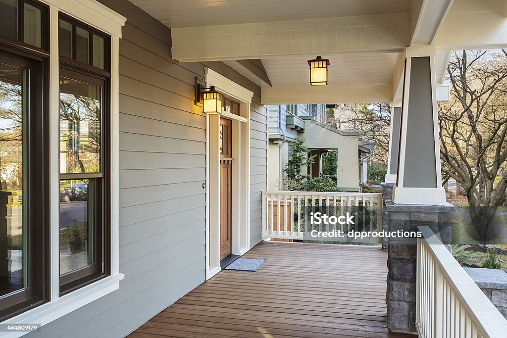 Large porch exterior of an upscale home with lights Horizontal Shot of wrap around porch on an upscale home Porch Stock Photo