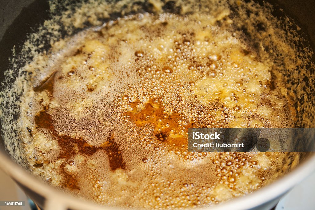 preparing melted butter ghee Closeup of preparing melted butter ghee in cast iron pot Butter Stock Photo