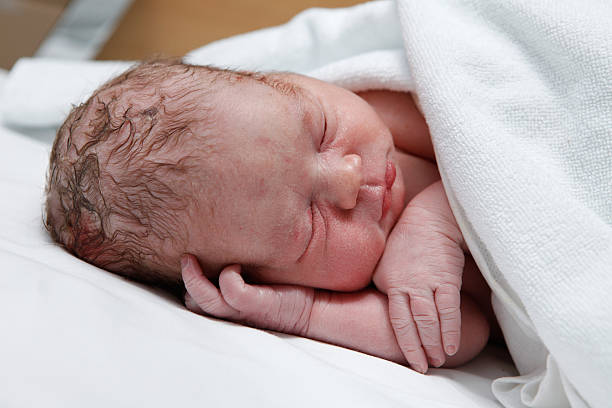 istock Newborn baby sleeping on his side on white blanket 464812338