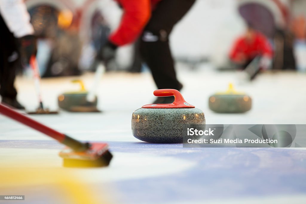 Sport of curling being played on a field Curling stones on ice Curling - Sport Stock Photo