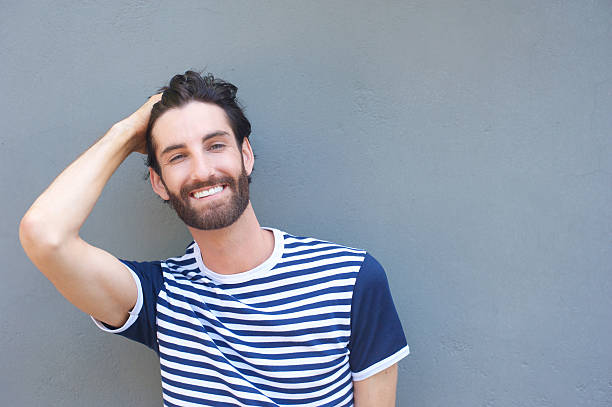 istock Handsome young man smiling with hand in hair 464819772