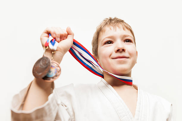 istock Smiling karate champion child boy gesturing for victory triumph 464825882