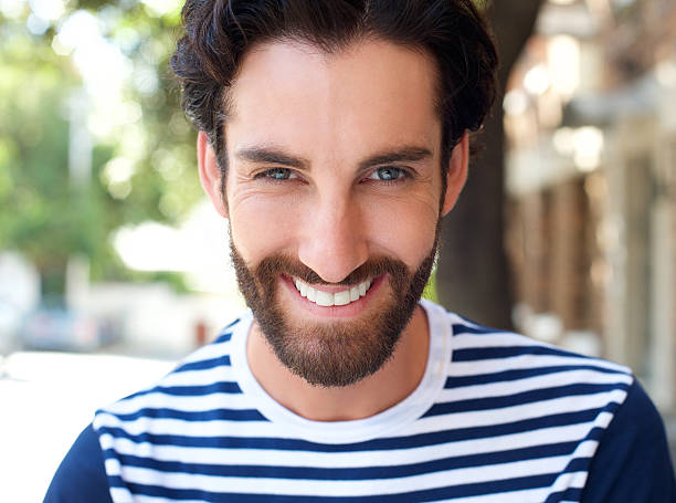 istock Smiling young man with beard and striped shirt 464826286