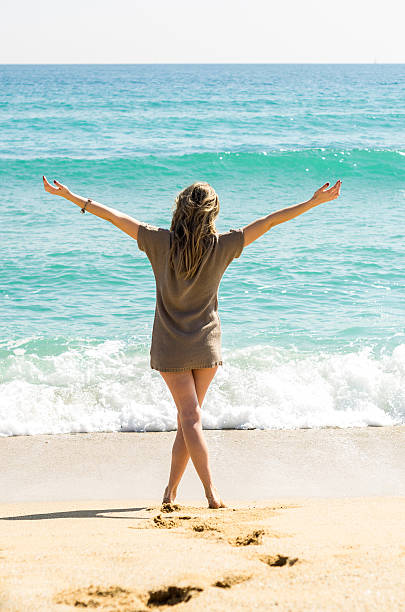 istock footprints sand girl beach hands up vertical open 464826624