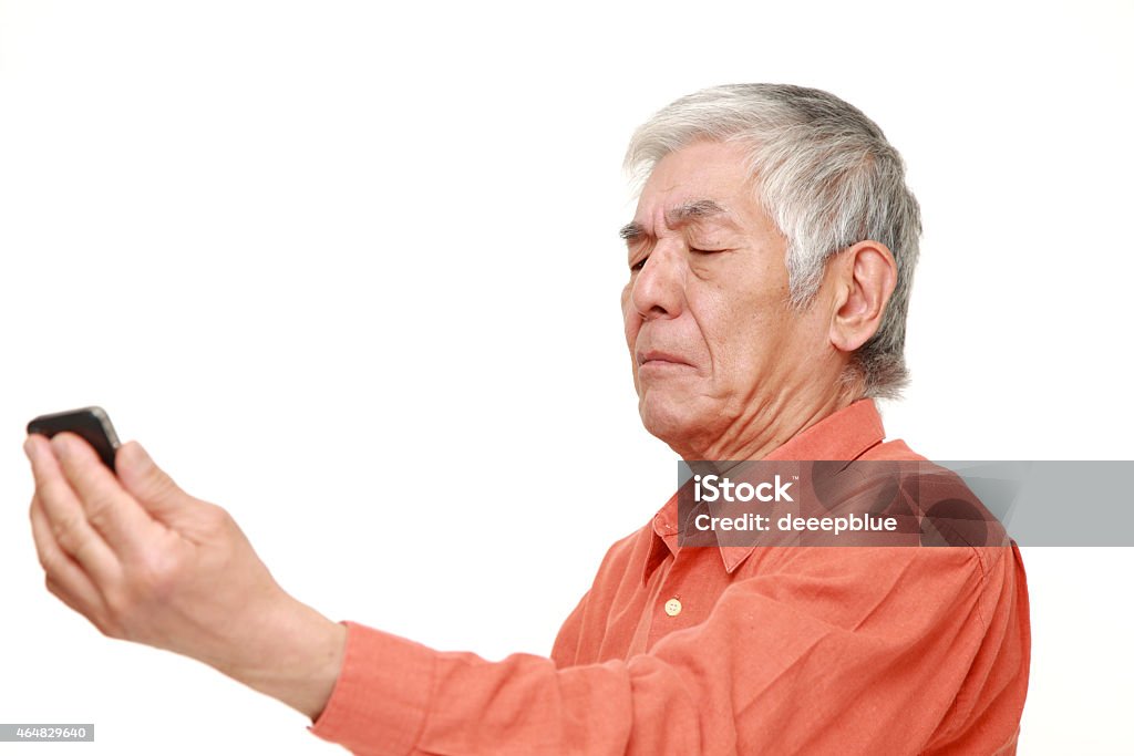 senior Japanese man with presbyopia portrait of senior Japanese man with presbyopia on white background Presbyopia Stock Photo