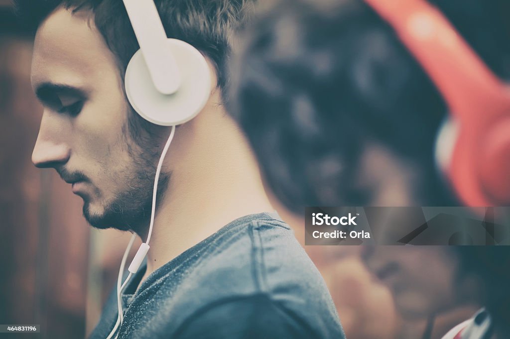 Male and female with headphones on Couple listening to music on headphones Headphones Stock Photo