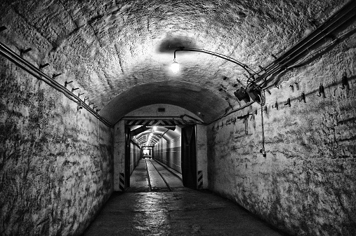 A lone person walks through a historic mining tunnel