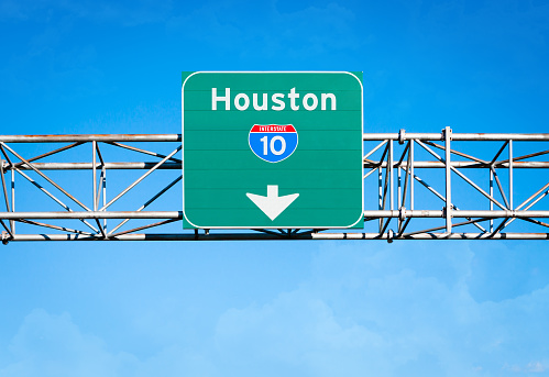 An elevated overhead highway sign. It reads 
