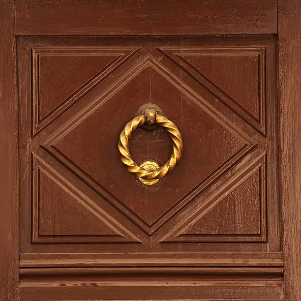 Antique brass doorhandle on a wooden door