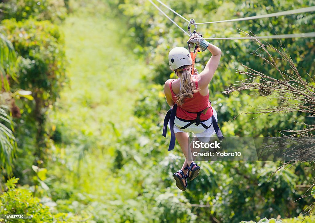 Woman going on a jungle zipline adventure Woman enjoying a fun zip line tour in the jungle while on vacation Zip Line Stock Photo