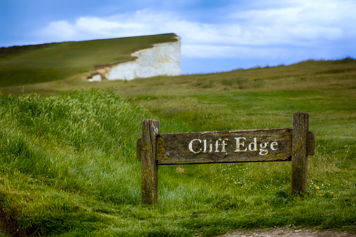 Warning sign at the edge of Dover Cliffs, East Sussex, England.