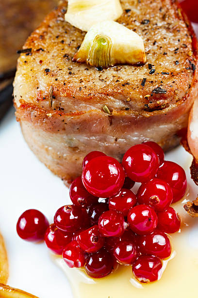 istock Steak fried in bacon with cranberry, pepper, honey and garlic. 464847576