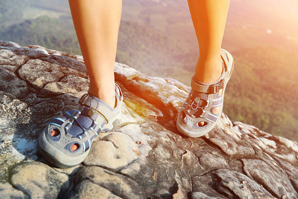 istock woman legs climbing  mountain peak cliff 464848052