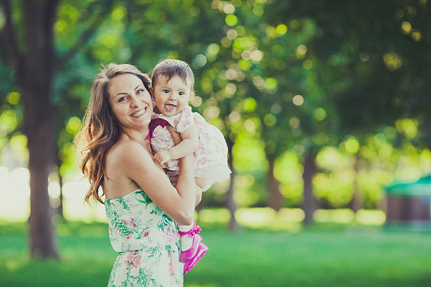 istock Young mother holding daughter in a park 464848896