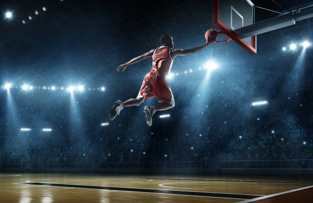 istock Basketball player making a slam dunk with fans watching 464849676