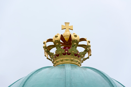 The royal crown atop of the boating house from which the queen of Denmark steps aboard the small boat taking her to the royal yacht \