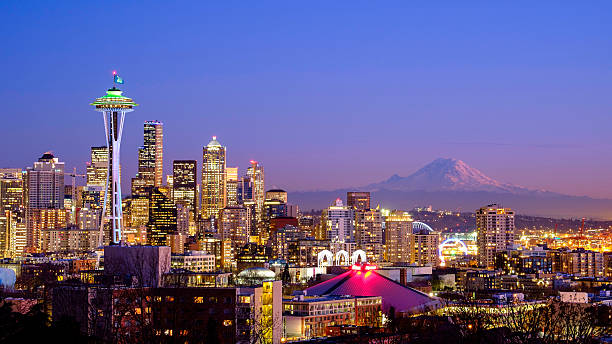 Seattle skyline at night with Mt Rainier in the distance  A scenic view of the Space Needle in Seattle, WA and the Mt. Rainier is visible in the background. This picture taken from Kerry Park, Queen Anne area on January 29, 2015 at 17:50.  washington state photos stock pictures, royalty-free photos & images