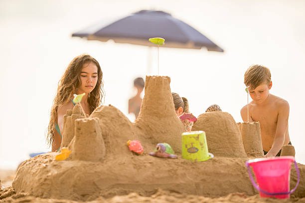istock Kids building a sandcastle on the beach in Hawaii 464852766