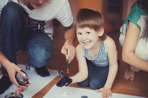 istock Smiling Young Boy Painting With Father 464854254