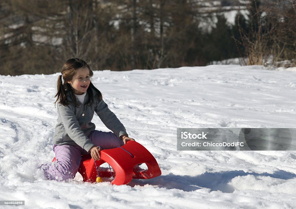 young girl juega con la Red sled en la nieve - Foto de stock de 2015 libre de derechos