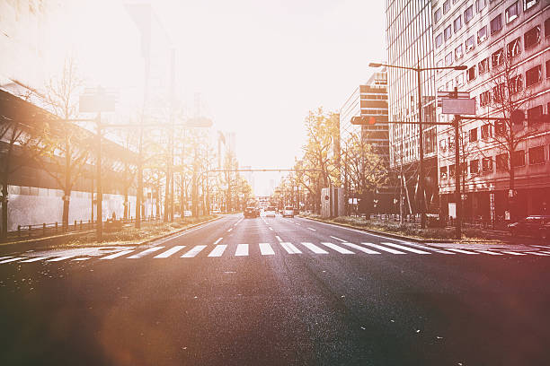 Pedestrian crossing across a wide street. The red traffic light is on.