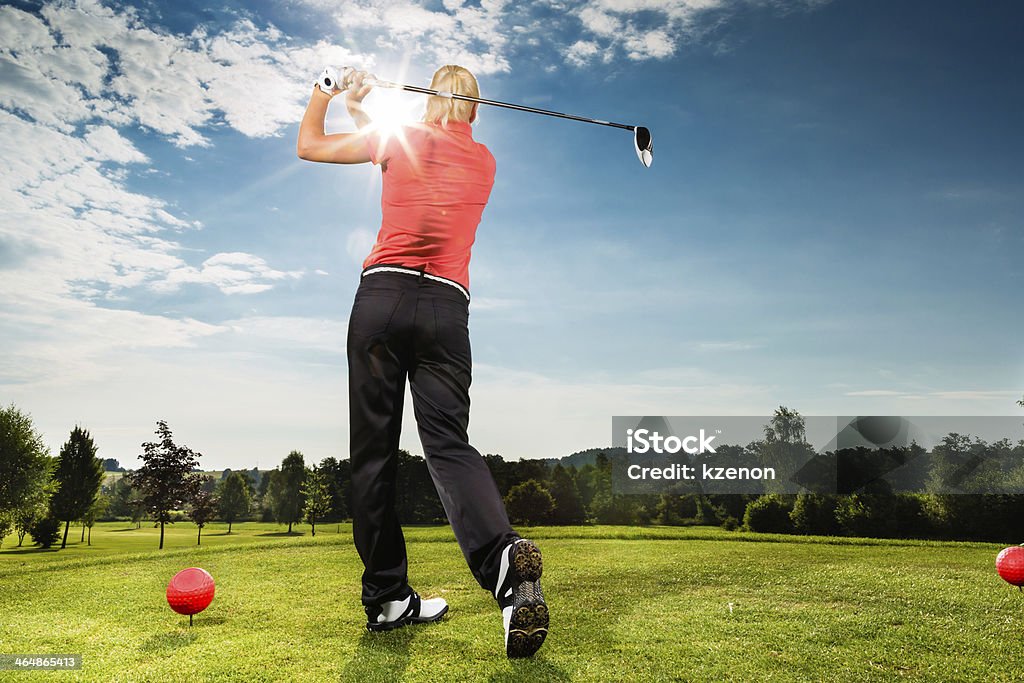 Young woman on course doing golf swing Young female golf player on course doing golf swing, she presumably does exercise Golf Swing Stock Photo