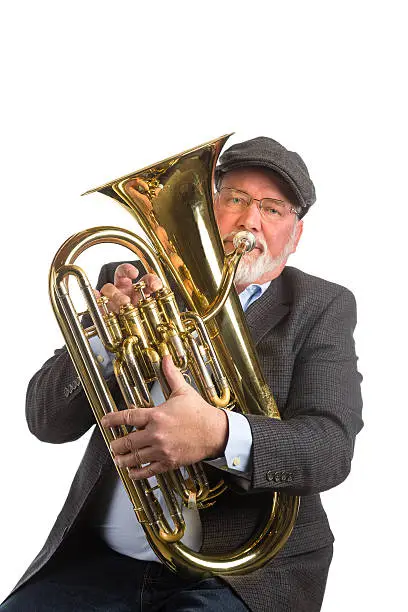 A man playing a vintage silver tuba.