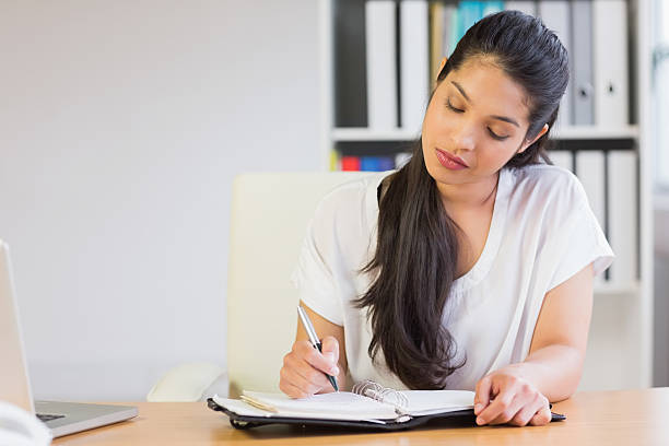 istock Young businesswoman writing in diary 464869564