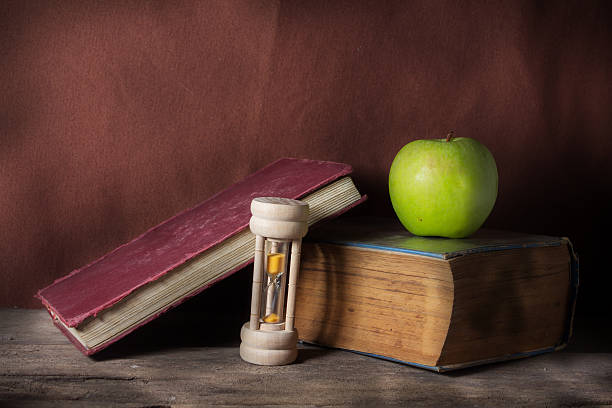 istock Still life apple with hourglass and books. 464870135