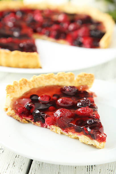 istock Fresh berry tart on plate on white wooden background 464876606