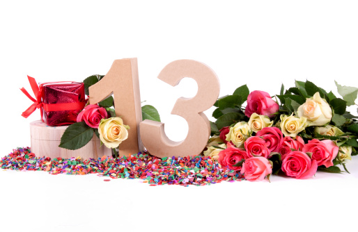 Number of age in a colorful studio setting with fresh roses on a bottom of confetti