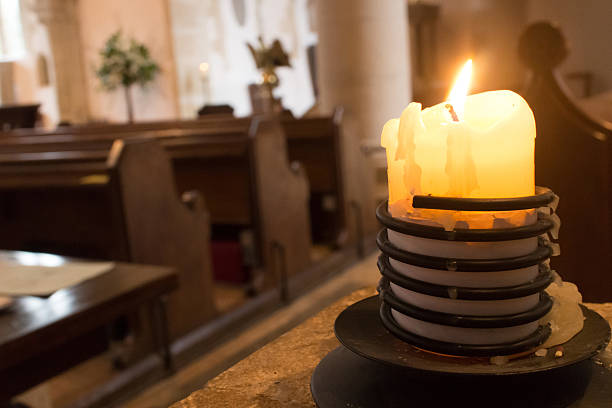 istock Large church candle flickering inside a church 464884232