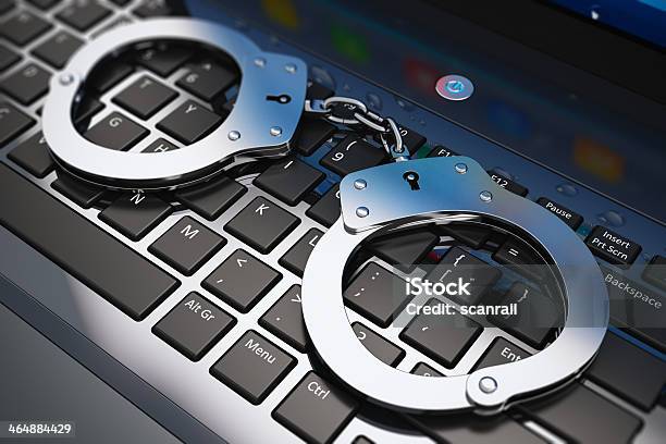 Handcuffs On Laptop Keyboard Stock Photo - Download Image Now - Computer Keyboard, E-Mail, Handcuffs