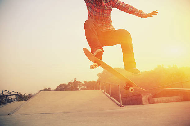 istock A skateboarder jumping his board at a skate park at sunset  464886390
