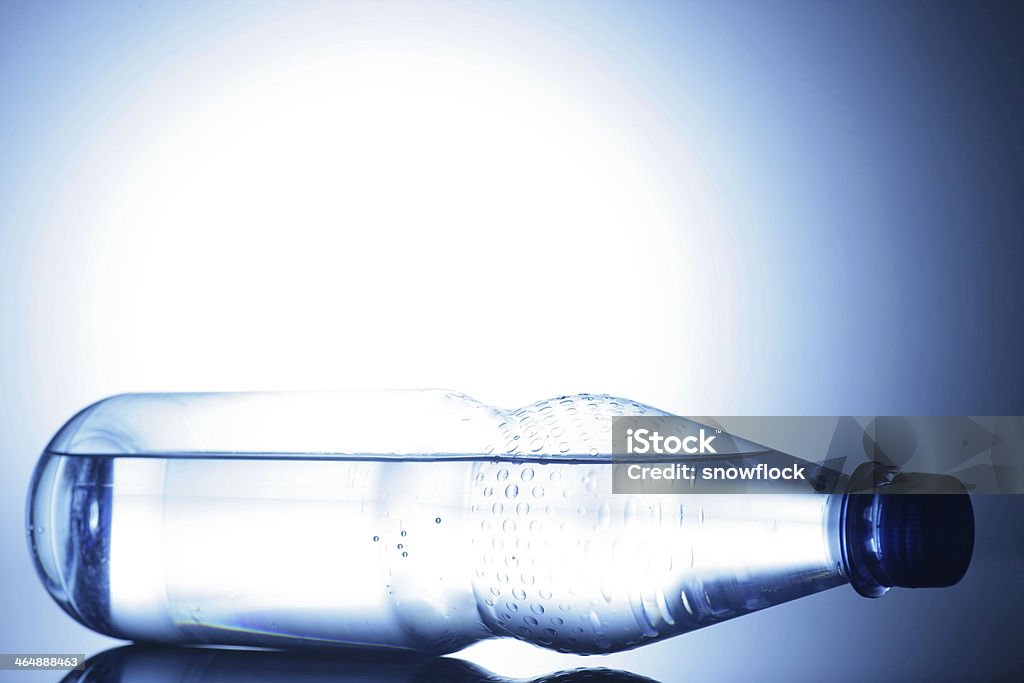 Water water bottle on a shiny surface in studio Blue Stock Photo