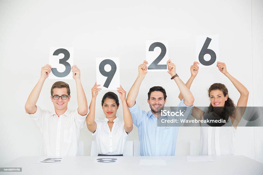 Panel judges holding score signs Portrait of panel judges holding score signs in office Score Card Stock Photo