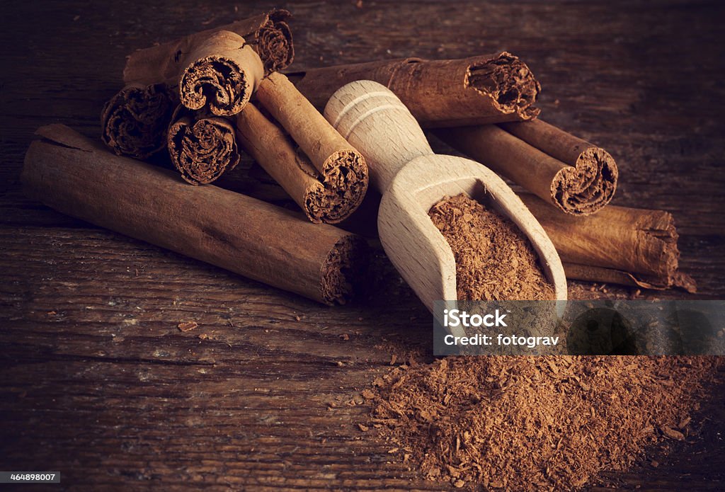Sticks and ground ceylon cinnamon Sticks and ground ceylon cinnamon with wood spoon on wooden table Cinnamon Stock Photo
