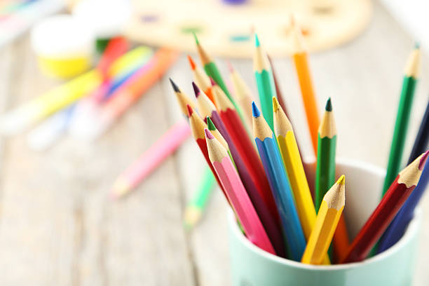 istock Colorful pencils in cup on grey wooden background 464899690