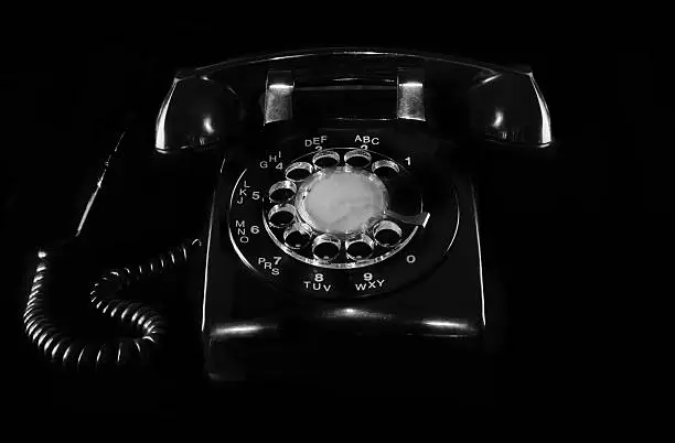 Retro-style, vintage black telephone on black background