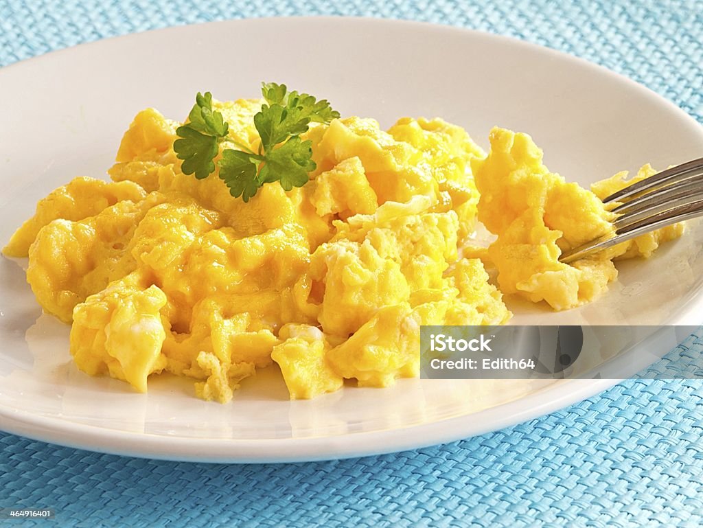 Scrambled eggs on a plate A plate of scrambled eggs garnished with parsley. Courthouse Stock Photo