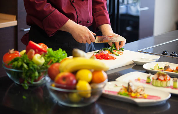 istock Midsection view of a man cutting vegetables in a kitchen 464925338