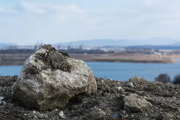 Old stone against the background of lake during the day