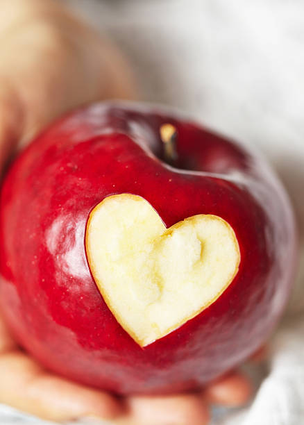 istock Hand holding red apple with heart 464931997