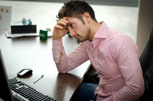 istock Preoccupied, worried young male worker staring at computer 464932511