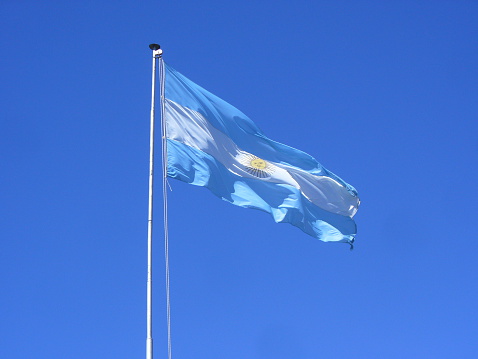 White flag over shiny blue sky