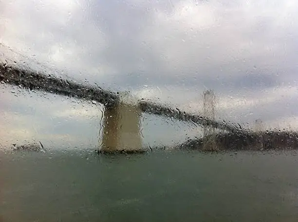 The westspan of the San Francisco Bay bridge as seen thought the rain spattered window of the ferry