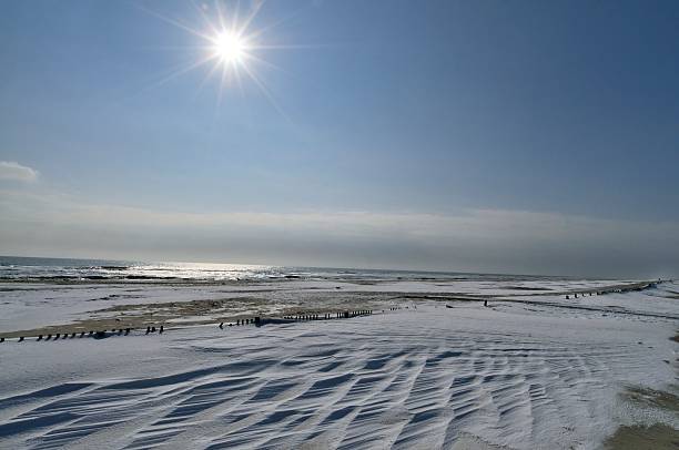 Aeolian snow drifts add some nice texture to this landscape of the Assateague island beach with a high aperture yielding a nice sun burst effects on a cold February day.