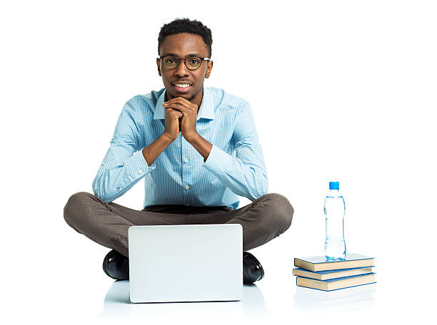 szczęśliwy african american college student siedzi z laptopa na biały - sitting young men book isolated on white zdjęcia i obrazy z banku zdjęć